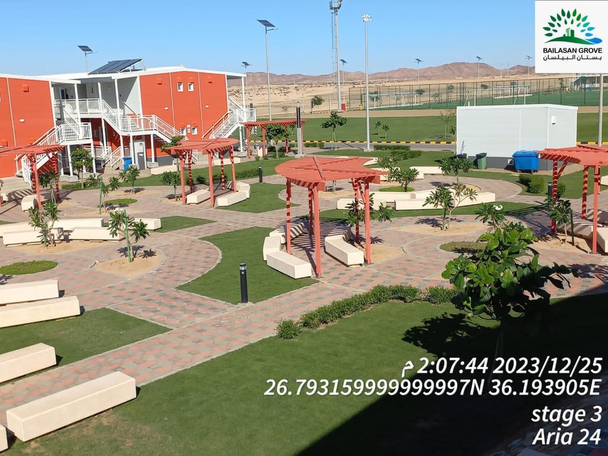 Completed hardscape courtyard with pergolas, turf, planter boxes, and paths